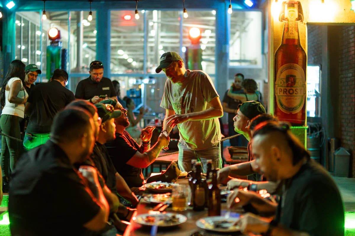 Mesa larga con churrasco y cerveza en el Fabrik Tour de Prost